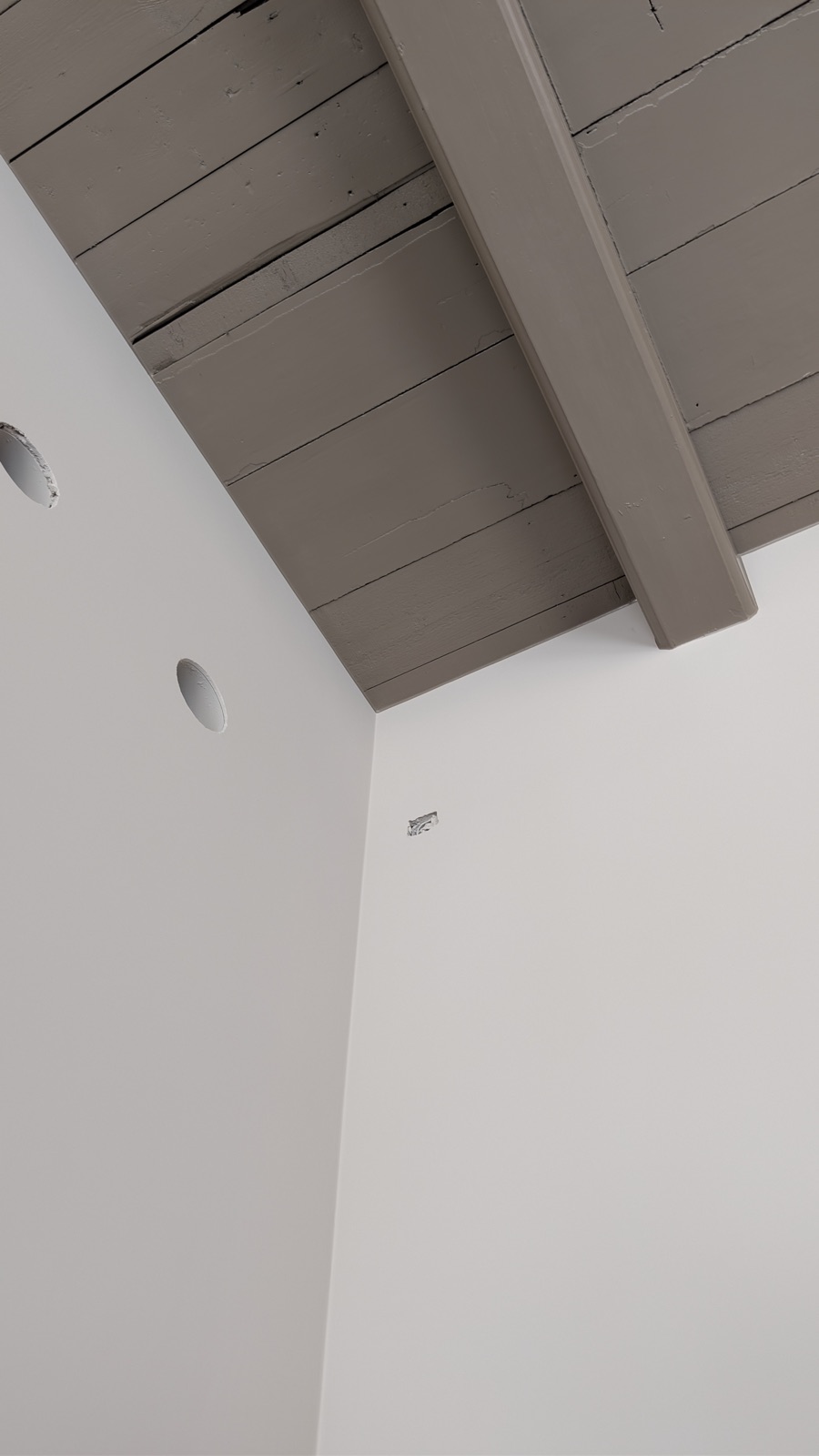 Detail van een gespoten balkenplafond met strak afgewerkte witte wanden