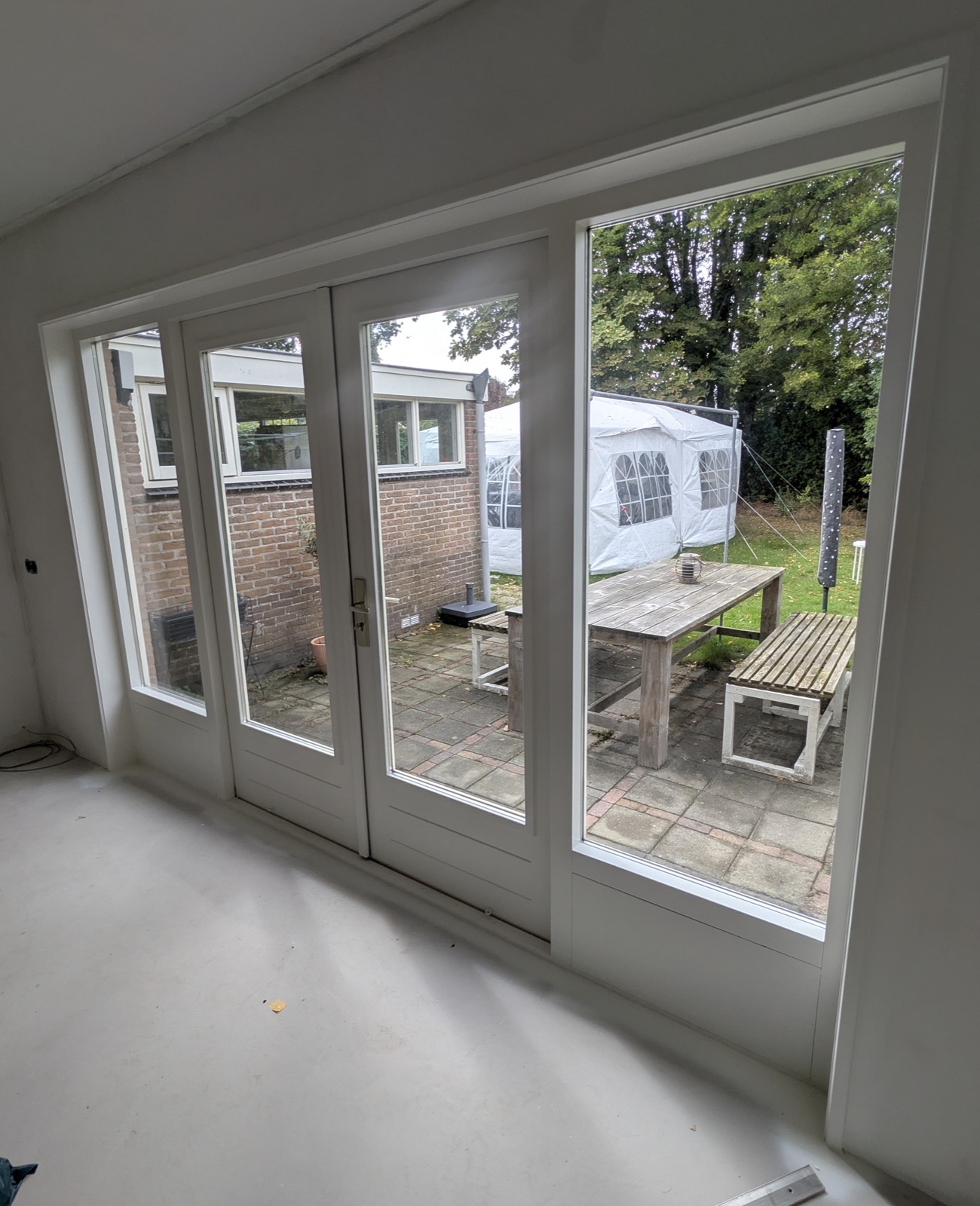 Wit geschilderde openslaande deuren met zicht op de tuin